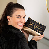 Frau hält GNTM Schminktasche - schwarz/gold mit goldener Unterseite und schwarzem Design im Los Angeles Stil.