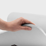 Hand, die die rutschfeste und robuste #DoYourFitness Fitnessmatte - In- & outdoor - Yoga, Gymnastik & Co. - 183 x 61 x 0,8 cm - Weiß hält.