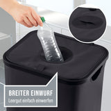 Eine Hand stellt eine leere Plastikflasche in den WELLENBORG Pfandflaschen-Sammelbehälter, 100l, mit breiter kreisförmiger Öffnung und Klettverschluss. Leicht transportierbar mit 2 Tragetaschen. Deutscher Text: „Weite Öffnung – Leergut einfach abstellen.“.