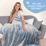 MAXXMEE Verwandlungskissen Glow in the dark – weiches Kuschelkissen, das sich in eine leuchtende Kuscheldecke mit Dinosaurier-Motiv verwandelt.
