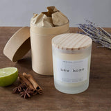 Luma Lab Series Duftkerze Mood "New Home" in stilvollem Glas mit Zimtstangen, Sternanis und Limette auf Holzfläche präsentiert.