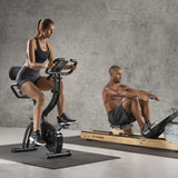 FitEngine Heimtrainer mit Expanderbändern - schwarz mit höhenverstellbarem Sattel und großem Display für effektives Cardio-Training.