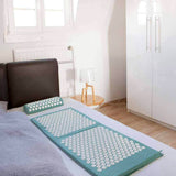 #DoYourFitness Akupressur-Set Bikash mit Massagematte und Entspannungs-Kopfkissen in Blau auf Bett liegend.