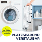 Eine Person stellt den EASYmaxx Teleskop-Wäscheständer 800 (auszieh- & klappbar, 8m Trockenlänge) neben Waschmaschine und Regal. Das platzsparende Design eignet sich ideal für kleine Wohnungen und macht das Trocknen besonders einfach.