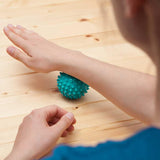 #DoYourSports Igelball & Faszienball - Massageball ⌀ 8 cm - Hellblau in Anwendung zur punktuellen Muskel- und Faszienmassage.