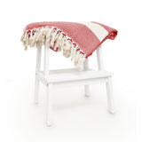 LUMALAND Baumwolldecke / Tagesdecke aus 100 % Baumwolle - ca. 200 x 240 cm - Rubin Rot auf weißem Hocker mit Fransen.