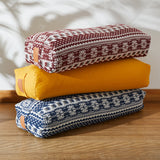 #DoYourYoga Yoga-Bolster Paravati - gefüllt mit Bio-Buchweizenschalen - 67 x 22 x 13 cm - Style 5 (Orange-Weiß) liegend gestapelt auf Holzboden.