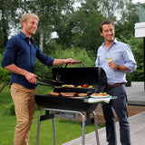 LANDMANN Holzkohle-Barrelgrill CG-III-660BK mit emailliertem Rost, temperaturanzeige im Deckel und höhenverstellbarem Kohlerost im Einsatz.