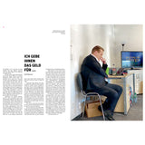 Ein Mann im Anzug sitzt nachdenklich an einem Schreibtisch mit Fernseher in einem modernen, minimalistischen Büroraum.