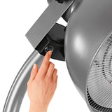 Hoberg Infrarot-Heizstrahler mit Standfuß zeigt Hand an Bedientaste des verstellbaren Lampenkopfes in modernem Design.