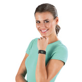Frau trägt VITALmaxx Fitness-Armband - Schwarz mit beleuchtetem LCD, Schritt- und Kalorienerfassung, verstellbarem Silikonarmband.