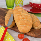 Kinderleichte Becherküche Set inkl. Messbecher-Set – frisches Brot auf Holzbrett mit Tomaten und Messer.