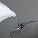 LAZY LEAF Blumentopf selbstgießend 1,1 Liter in weiß/grau wird mit Wasser befüllt, zeigt einfache Handhabung und modernes Design.