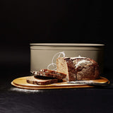 LUMALAND Cuisine Brotkasten Brotdose Brotbox aus Metall mit Bambus Deckel, oval, grau, mit frischem Brot und Bambus-Schneidebrett.