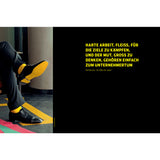 Person im Anzug mit gelben Socken sitzt im Schneidersitz neben deutschem Motivationstext auf schwarzem Hintergrund.