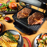 MAXXMEE Kontakt-Grill mit 6 Programmen - 2000W zeigt zwei Steaks auf großer, antihaftbeschichteter Grillplatte mit gegrilltem Gemüse.