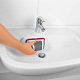 CLEANmaxx Akku-Scheuerbürste 3,7V rot/grau mit Handbürste wird kabellos im Waschbecken zur Reinigung genutzt.