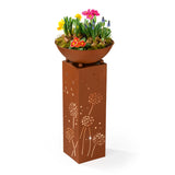 PRIMA GARDEN LED-Dekosäule mit Pflanzschale in Rost-Optik, warmweiße LED-Beleuchtung und dekorative Blumenarrangements.