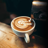 ESPRESSO-ULTIMATE Espresso-Siebträgermaschine - cremiger Milchschaum wird kunstvoll in Cappuccino gegossen.