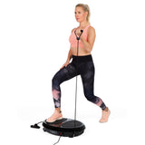 Frau trainiert mit VITALmaxx Vibrationstrainer rund 200W schwarz und Expanderbändern für Ganzkörpertraining zu Hause.