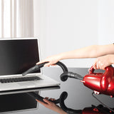 CLEANmaxx Multi-Handstaubsauger in Rot bläst und saugt Staub vom Laptop mit flexiblem Saugschlauch und Bürstaufsatz.