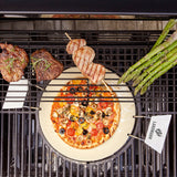 LANDMANN Pizzastein im Einsatz auf Grill mit Pizza, Gemüse, Fleisch und Grillspieß für vielseitiges Grillen und Backen.