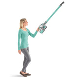 Frau hält CLEANmaxx Akku-Zyklon-Staubsauger türkis/grau mit verlängerbarem Aluminium-Steckrohr und Wandhalterung.