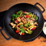 LANDMANN Grillwok aus emailliertem Gusseisen mit gebratenem Gemüse, ideal für Gas- und Holzkohlegrills, vielseitig und langlebig.