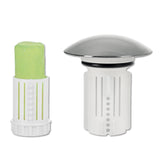 Grüner Toilettenspülkastenblock in einer weißen Halterung neben einem verchromten und weißen Toilettenspülkasten-Deodorant.