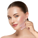 Frau nutzt MAXXMEE Gesichtsroller Perfect Face - Rosenquarz & Gua Sha Stein in weiß/rosegold zur Hautpflege und Hautdurchblutung.