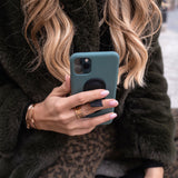 Frau hält Smartphone mit weißer flapgrip Handyhalterung – Smartphone-Halterung für sicheren Halt und einfache Bedienung.