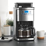 BEEM FRESH-AROMA-PERFECT SUPERIOR Filterkaffeemaschine mit Mahlwerk und 1,5 l Glaskanne auf Küchentheke mit Tasse.