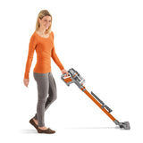 Frau reinigt mit MAXXMEE Akku-Zyklon-Staubsauger Pet Star - orange/silber, kabellos, handlich, elektrisch rotierende Bodendüse.