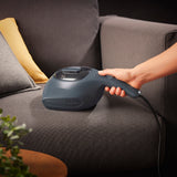 N8WERK Milbensauger in der Nordic Night Edition beim Absaugen eines Sofas mit UV-C-Licht und HEPA 11-Filter zur Desinfektion.