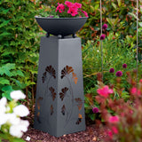 Hoberg LED Pflanzsäule in Beton-Optik 23x23x70 cm mit Gingkoblätter-Design und abnehmbarer Pflanzschale im Garten platziert.