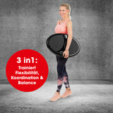 Frau trägt VITALmaxx Vibrationstrainer rund 200W schwarz, ideal für Flexibilität, Koordination und Balance im Ganzkörpertraining.