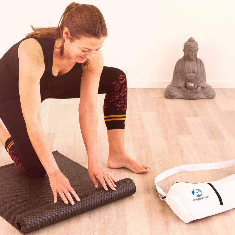 Frau rollt DoYourYoga Yogamatte Kirana - 183 x 61 x 0,4 cm - Caramel auf rutschfester, weicher Trainingsmatte aus ECO-PVC.